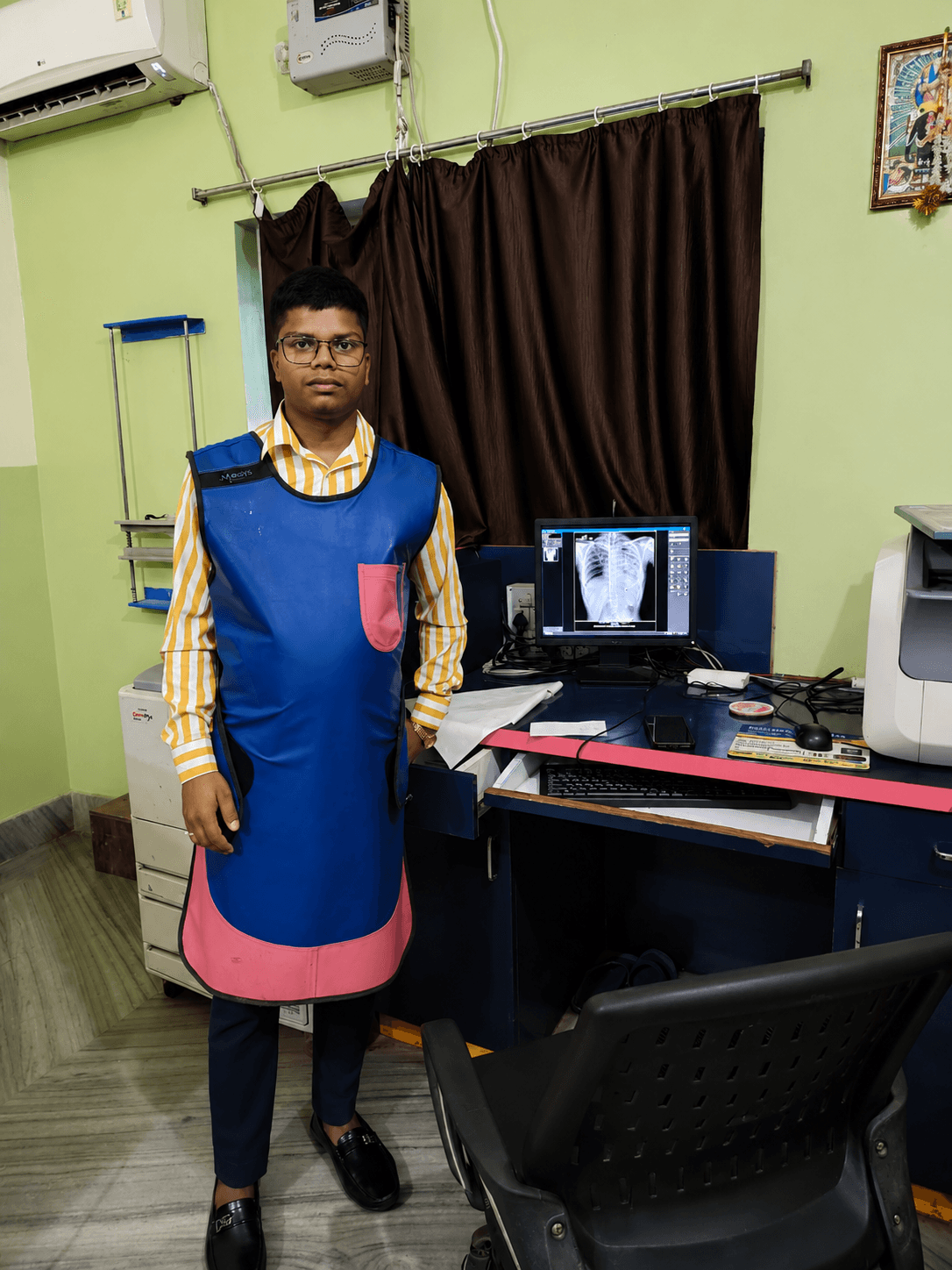 X-ray technician in protective gear at Dubey Nursing Home